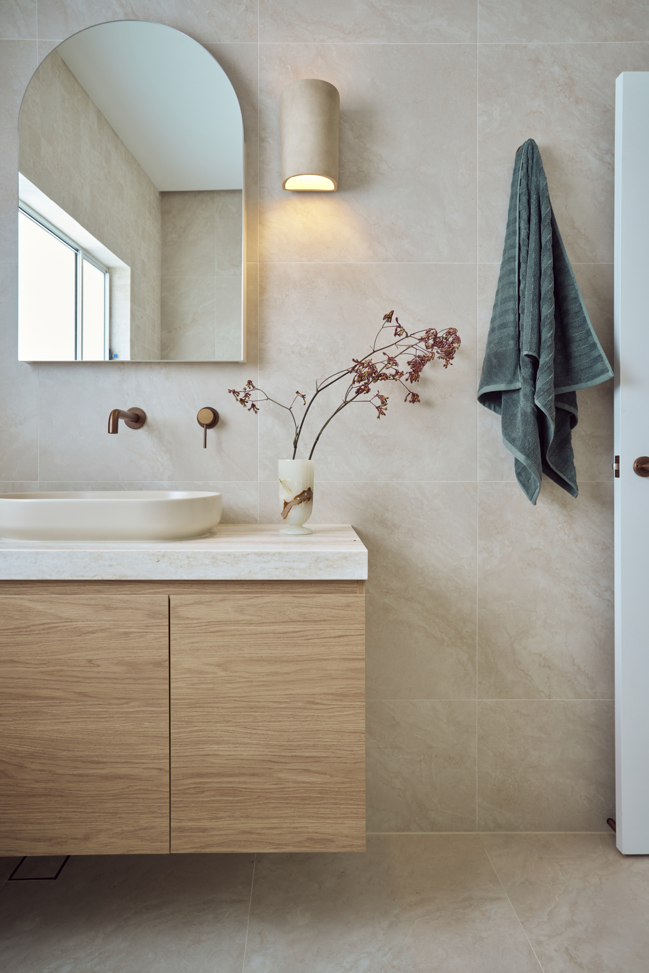 Renovated Mediterranean-style bathroom in Cronulla with curved shower screen, floating vanity and marble mosaic feature wall