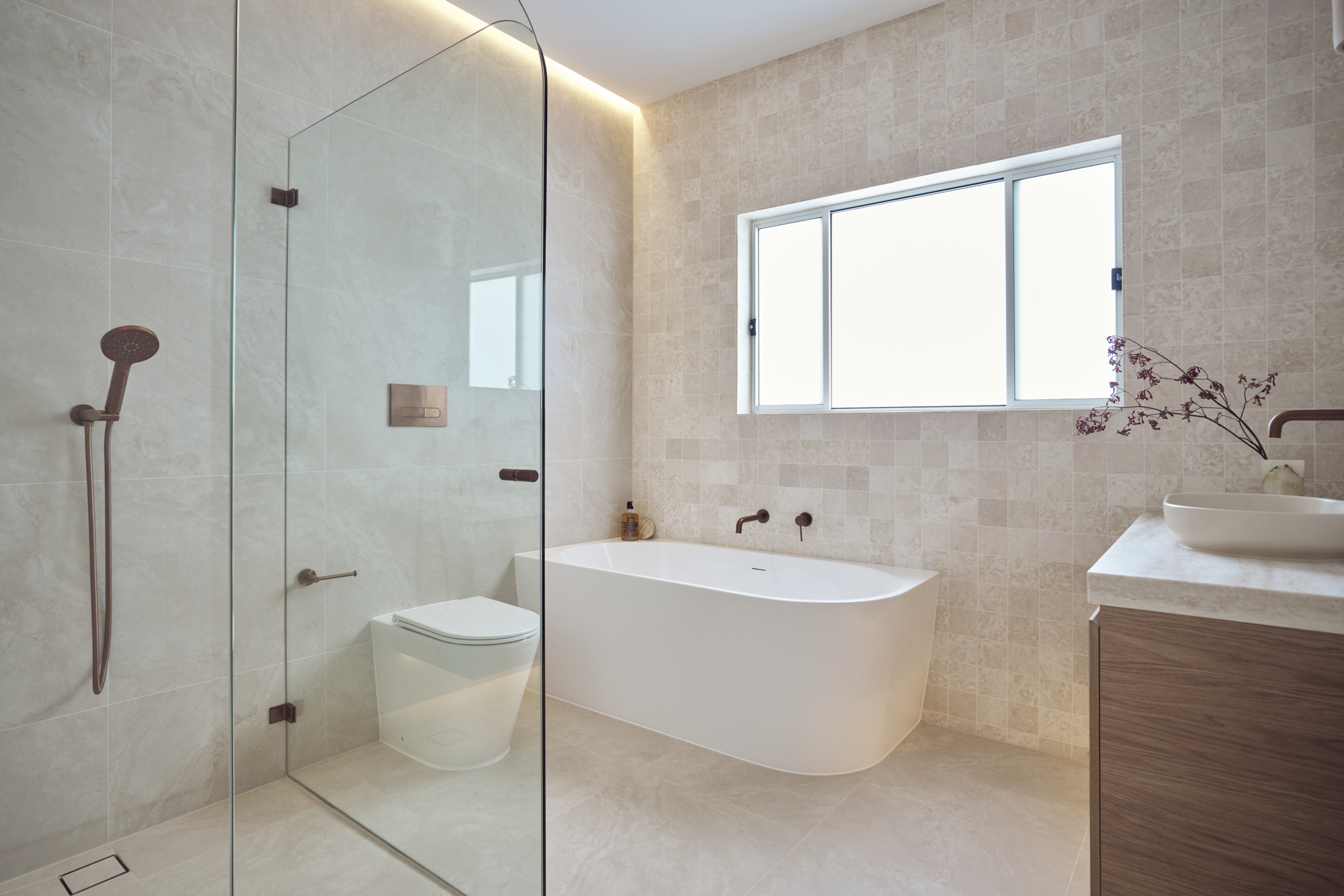 Modern bathroom renovation in Newtown with a floating vanity, walk-in shower and brushed bronze tapware.