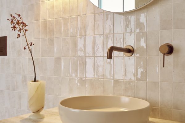 Sconce wall light with a timber vanity with wall-mounted mixers in brushed bronze